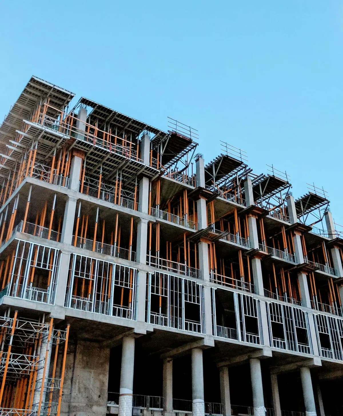 Edificio en construcción con estructura de hormigón y entramado metálico de fachada