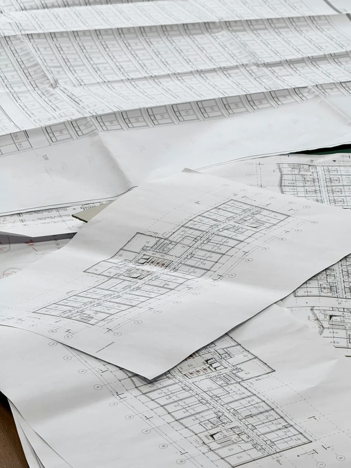 Planos de un edificio extendidos y superpuestos sobre una mesa