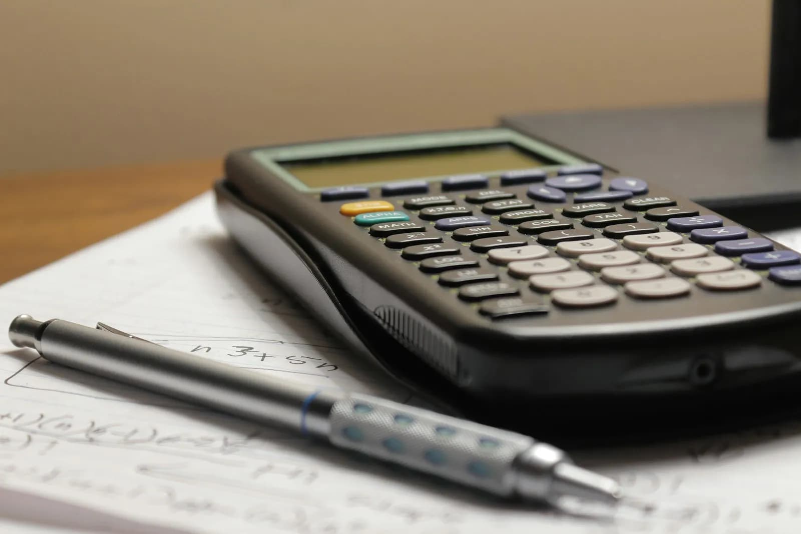 Calculadora y portaminas sobre una hoja con cálculos a mano