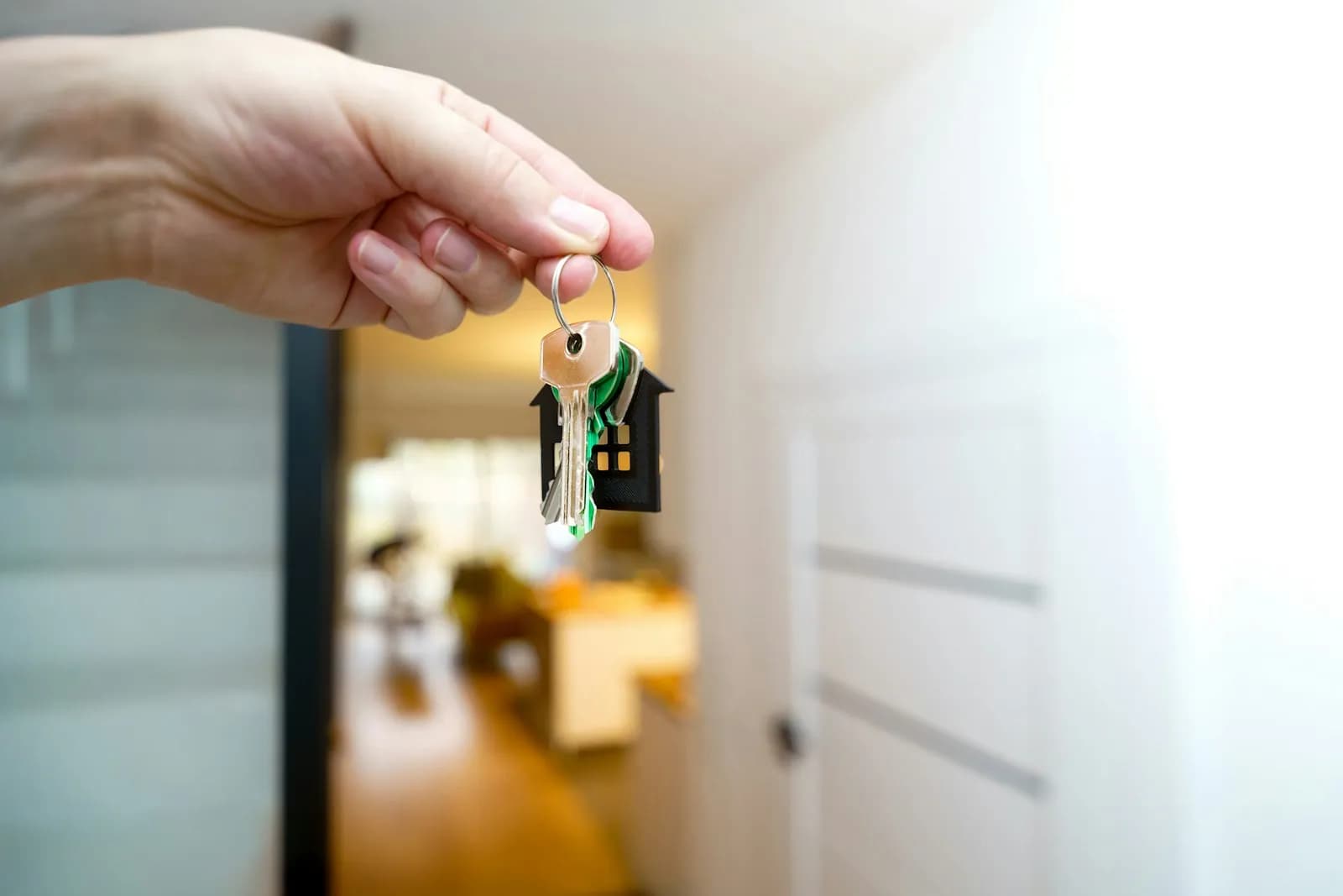 Mano que sostiene las llaves de una vivienda en el recibidor
